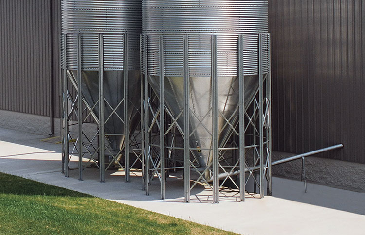 Bulk material storage silo with flexible or solid screw conveyor takeaway